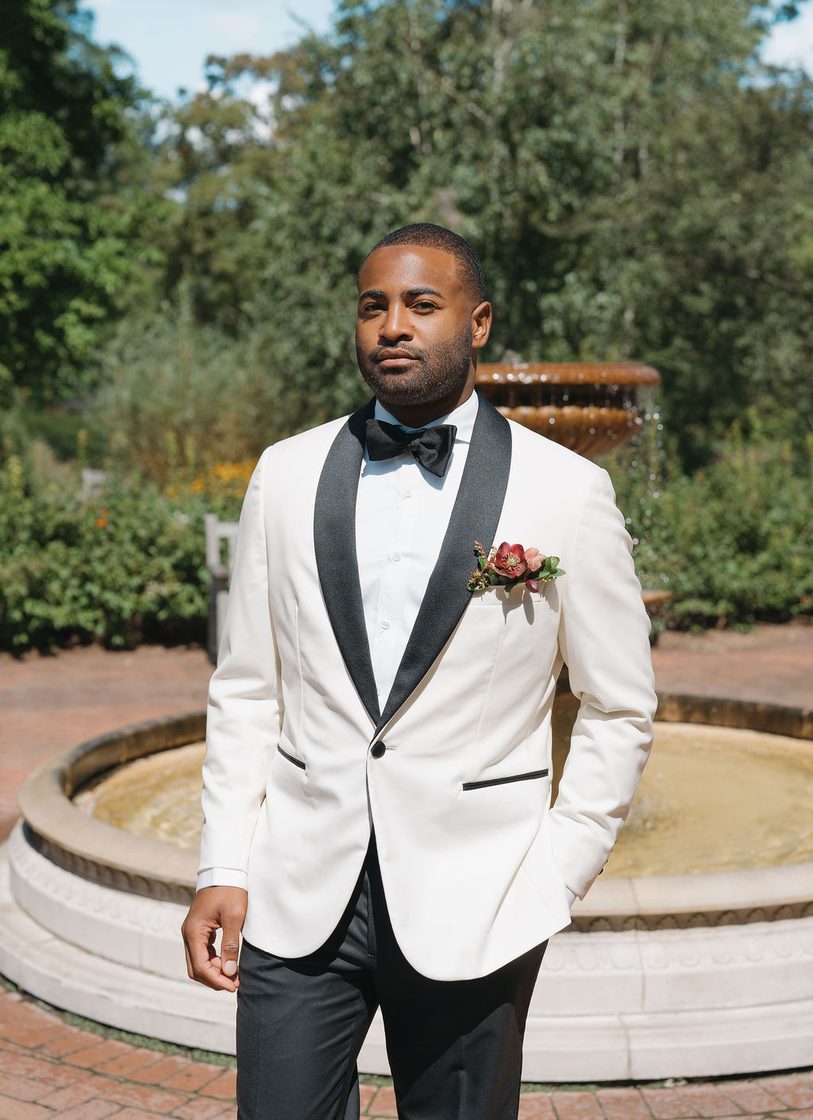 Groom in a custom ivory dinner jacket at the fountain